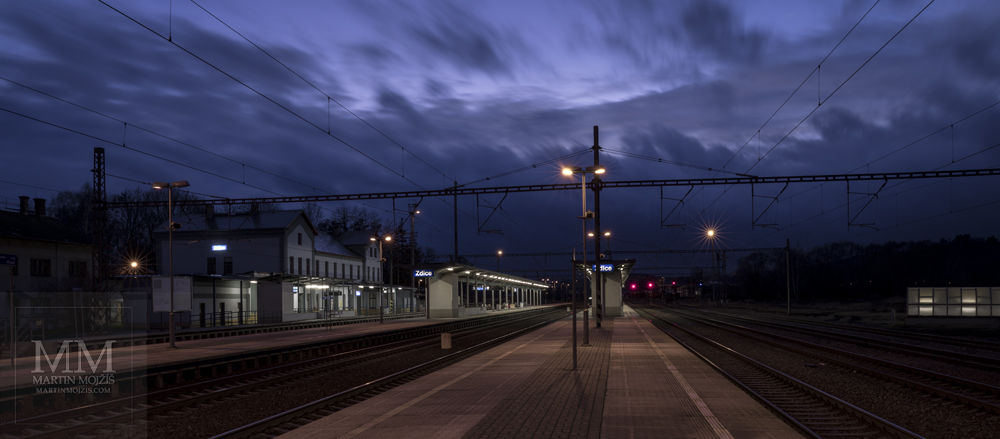 Železniční nádraží v soumraku. Fotografie zhotovená objektivem Canon RF 28 – 70 mm 1 : 2 L USM.